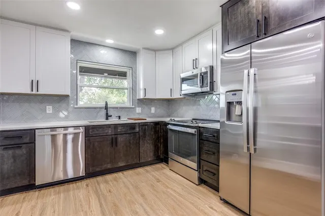 a kitchen with stainless steel appliances granite countertop a refrigerator and a sink