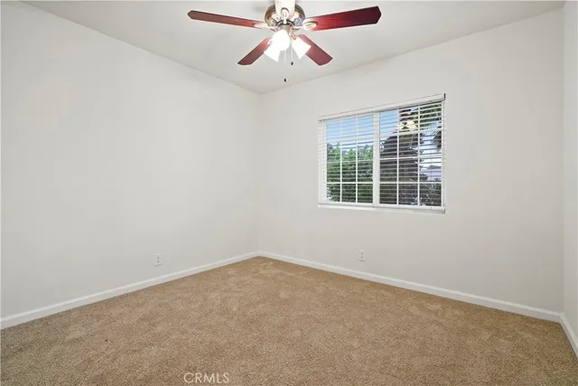 an empty room with a window and a fan