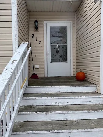 a view of wooden door and a window