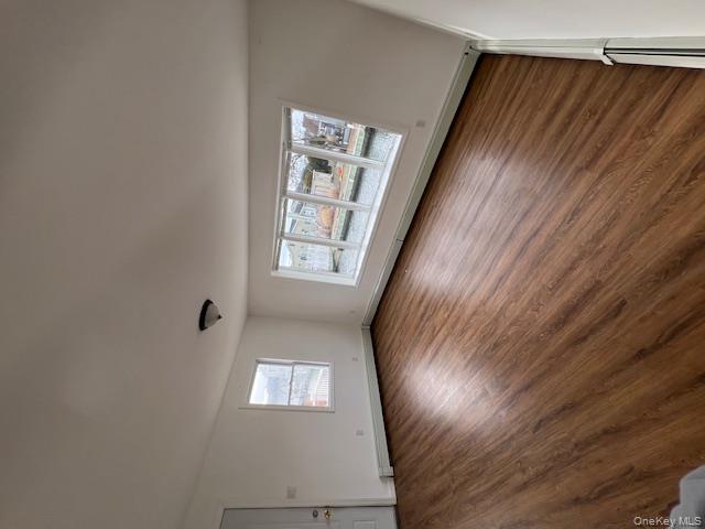 817 Ocean Street Lindenhurst, NY 11757 - Photo 7 of 14 an empty room with wooden floor and windows