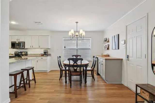 a view of a a dining room with furniture and chandelier