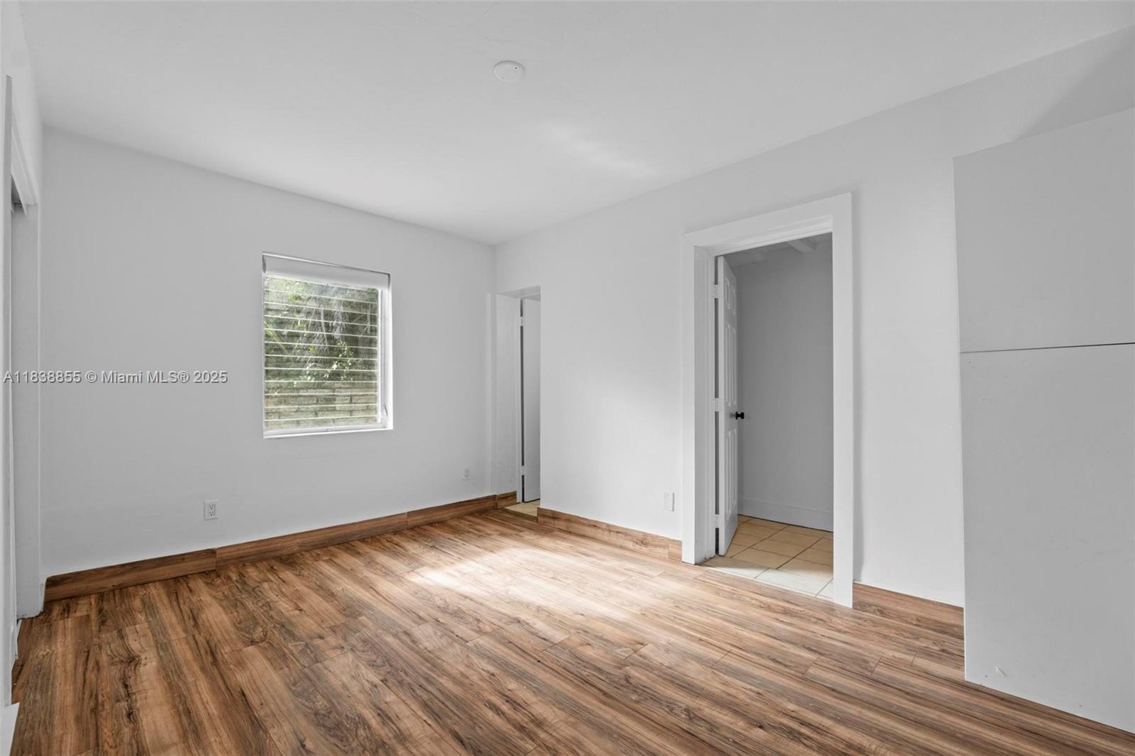 738 Fernwood Road Key Biscayne, FL 33149 - Photo 16 of 43 an empty room with wooden floor and windows