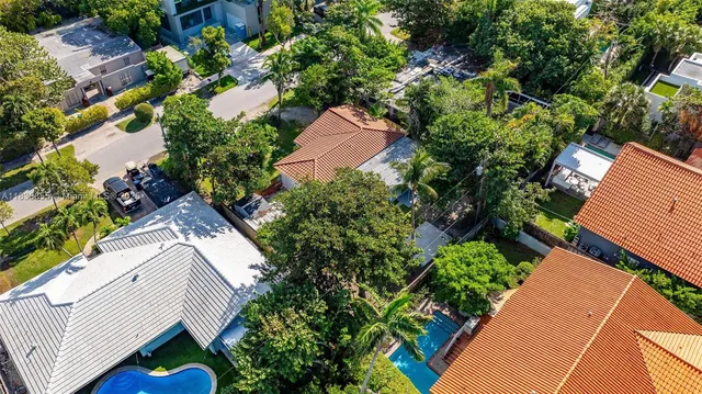 an aerial view of residential house with outdoor space and trees all around