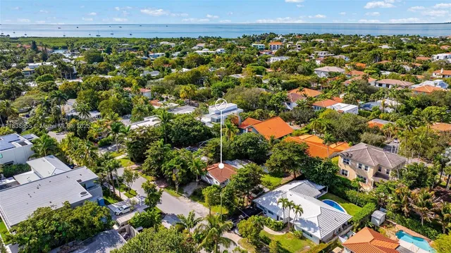 an aerial view of a residential houses with a yard and mountain