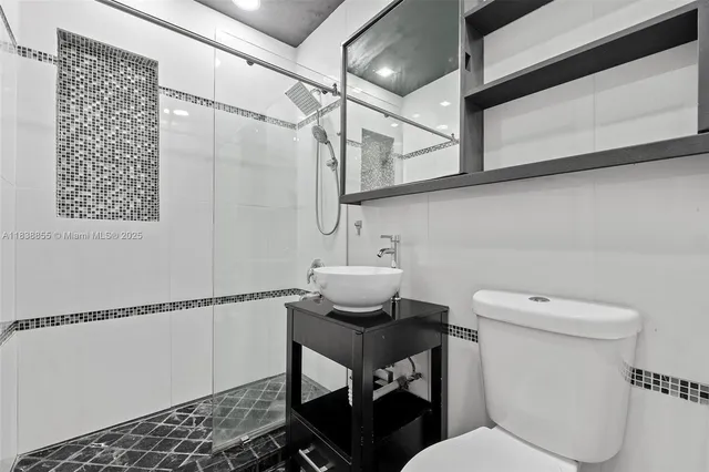 a bathroom with a toilet a sink and a mirror