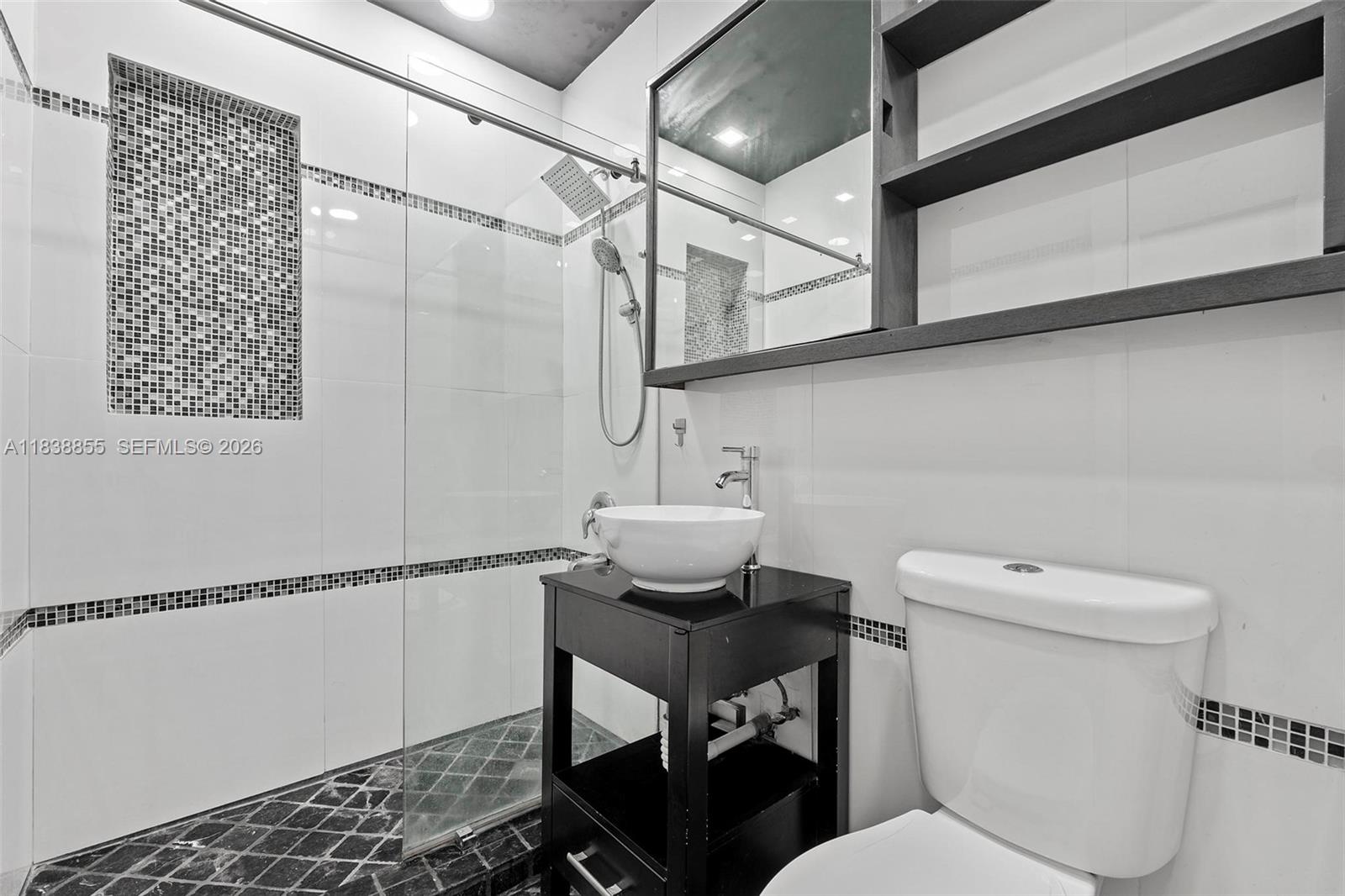 738 Fernwood Road Key Biscayne, FL 33149 - Photo 24 of 39 a bathroom with a toilet a sink and a mirror