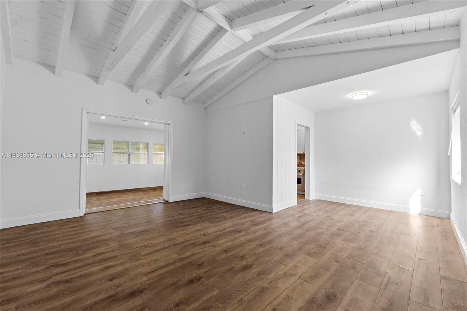 738 Fernwood Road Key Biscayne, FL 33149 - Photo 3 of 43 a view of an empty room with window and wooden floor