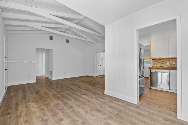a view of kitchen with granite countertop cabinets and refrigerator
