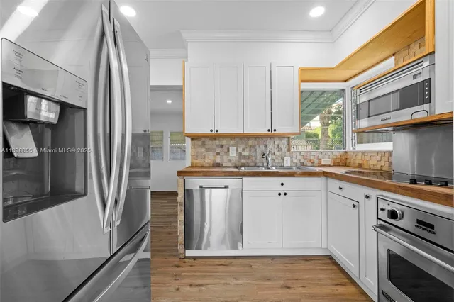 a kitchen with stainless steel appliances a stove sink and refrigerator
