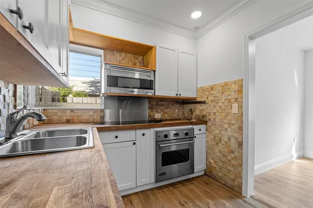 a kitchen with stainless steel appliances granite countertop a sink and a stove