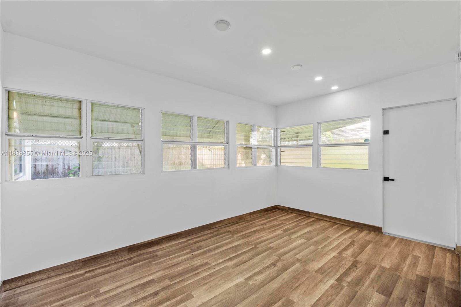 738 Fernwood Road Key Biscayne, FL 33149 - Photo 8 of 43 a view of an empty room with wooden floor and a window