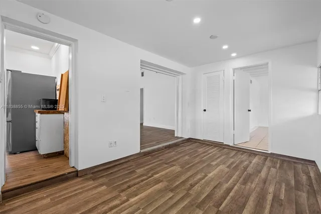a view of empty room with wooden floor
