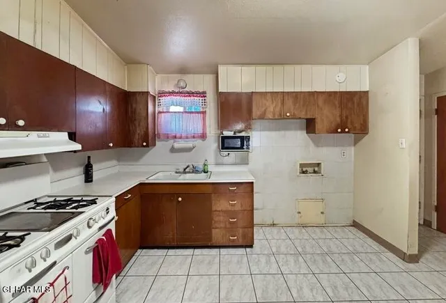 a kitchen with a stove sink and cabinets