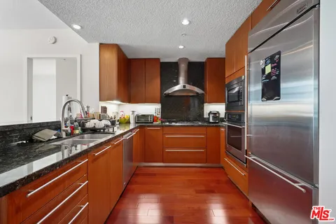 a kitchen with stainless steel appliances granite countertop a sink stove and cabinets