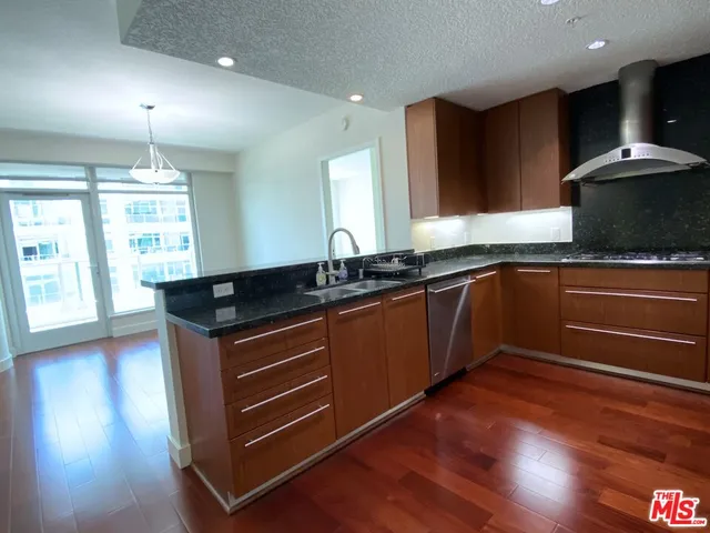 a kitchen with stainless steel appliances granite countertop a refrigerator and a stove