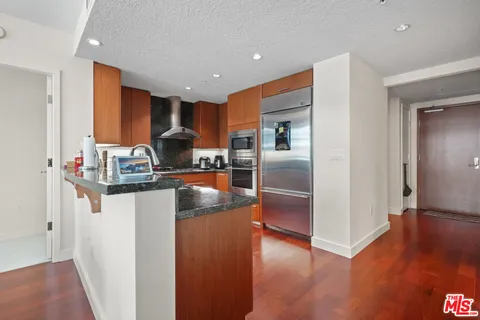 a kitchen with stainless steel appliances a refrigerator and wooden floor
