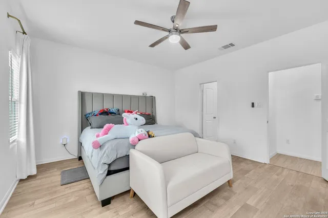 a bedroom with a bed and a chandelier fan