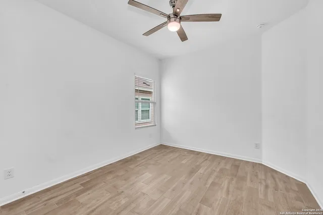 an empty room with a window and a fan