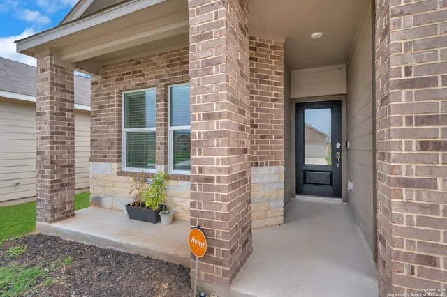 a view of a brick house with potted plants