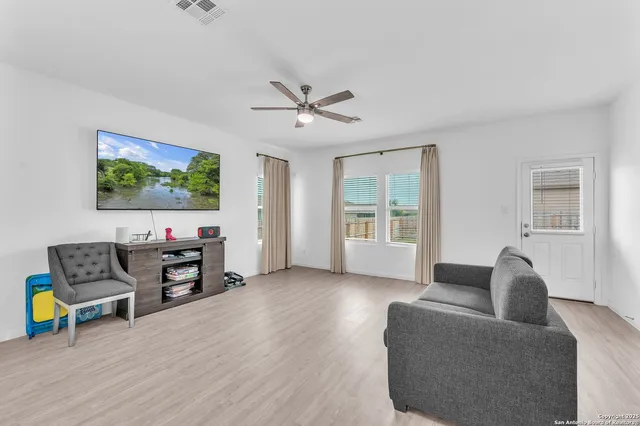 a living room with furniture and a flat screen tv with wooden floor