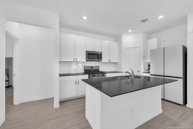 a kitchen with kitchen island a sink stove and refrigerator