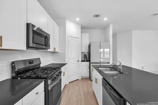 a kitchen with stainless steel appliances a sink stove and microwave
