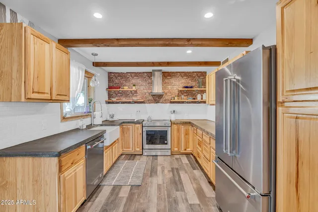 a large kitchen with a large window a sink and stainless steel appliances