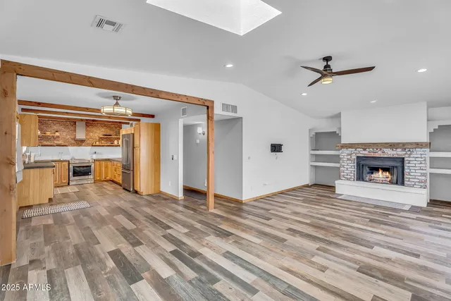 a view of an empty room with a fireplace and window