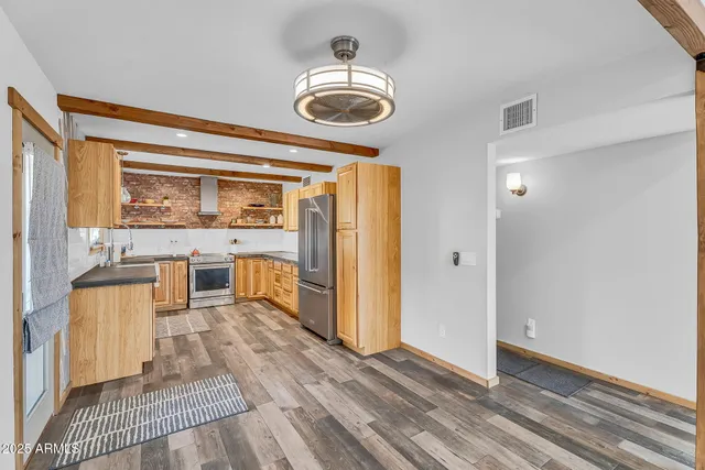 a view of a kitchen with wooden floor and a window