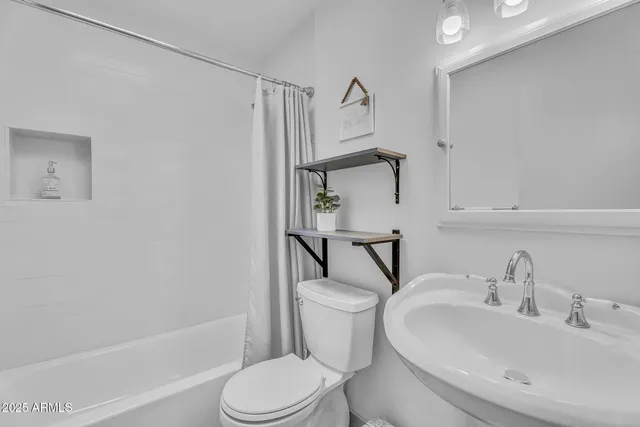 an empty room with wooden floor closet fan and windows