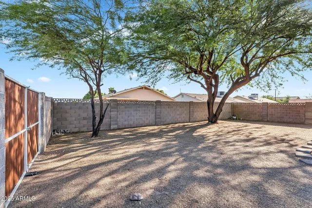 a backyard of a house with table and chairs