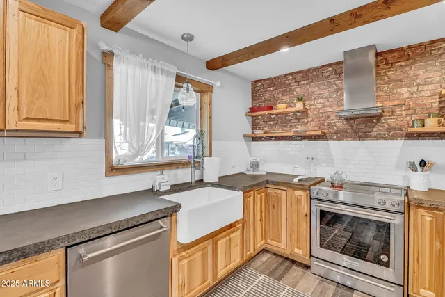 a large kitchen with a large window a sink and stainless steel appliances