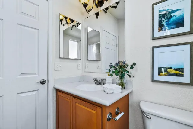 a bathroom with a sink a toilet and a mirror