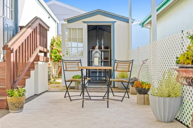 a view of two chairs and table in the balcony