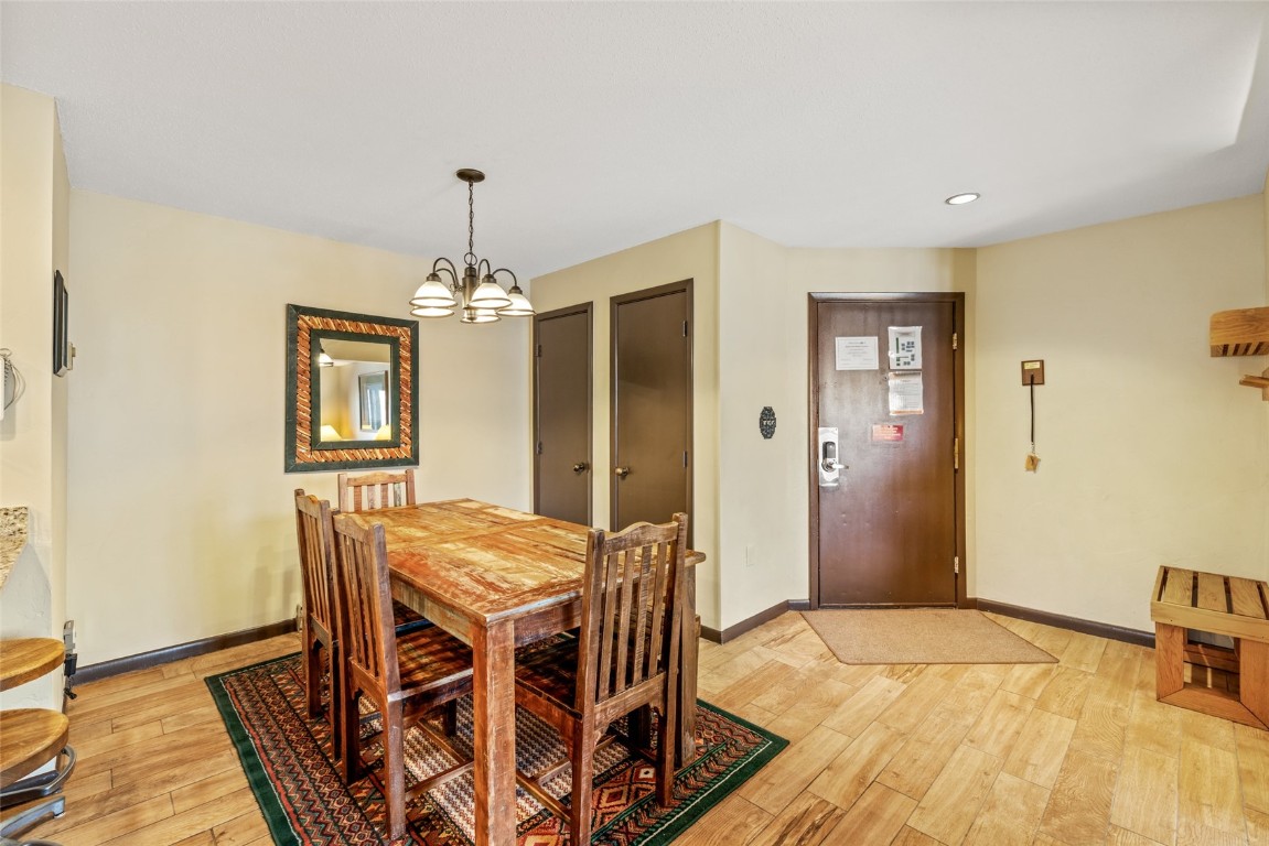 2015 Walton Creek Road, Unit 105 Steamboat Springs, CO 80487 - Photo 11 of 34 a livingroom with dining area a chandelier a wooden table and chairs