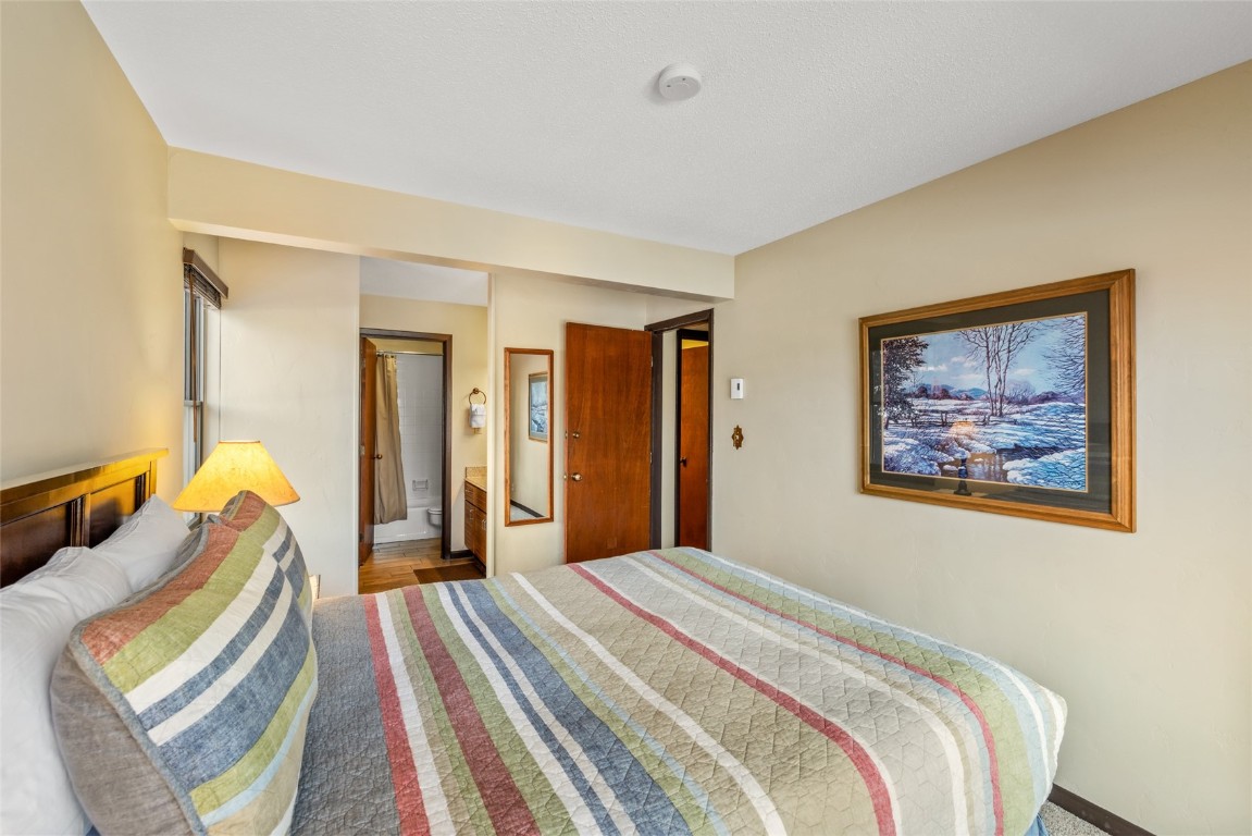 2015 Walton Creek Road, Unit 105 Steamboat Springs, CO 80487 - Photo 13 of 34 a bedroom with bed and a painting on the wall