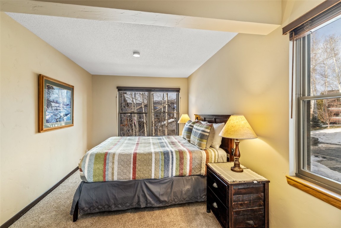2015 Walton Creek Road, Unit 105 Steamboat Springs, CO 80487 - Photo 14 of 34 a bedroom with a bed and wooden floor