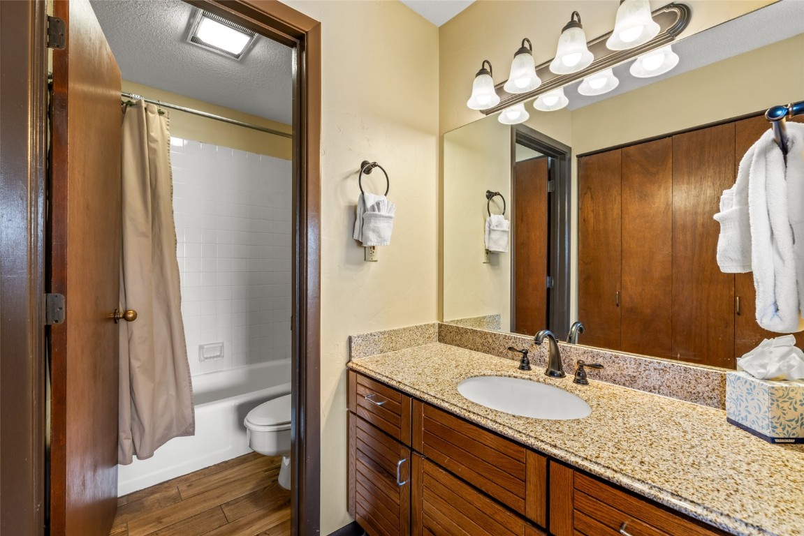2015 Walton Creek Road, Unit 105 Steamboat Springs, CO 80487 - Photo 15 of 34 a bathroom with a granite countertop sink a toilet and a mirror