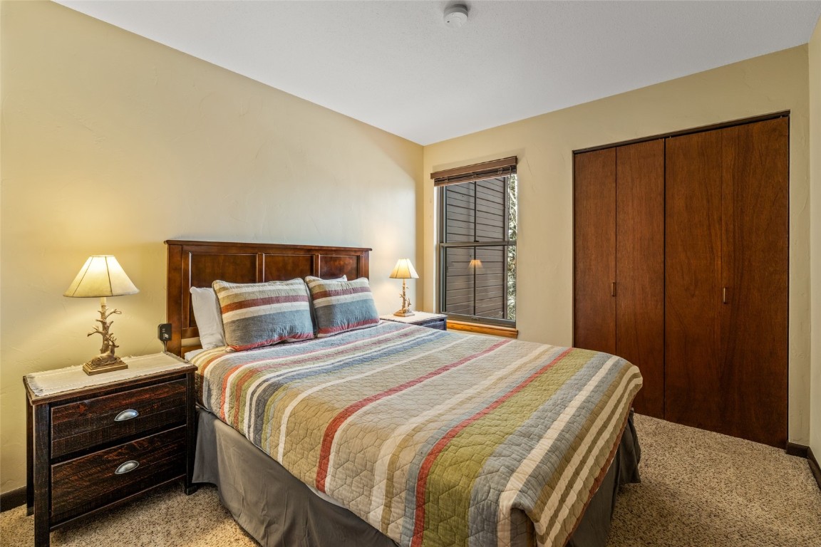 2015 Walton Creek Road, Unit 105 Steamboat Springs, CO 80487 - Photo 17 of 34 a bedroom with a bed and a lamp