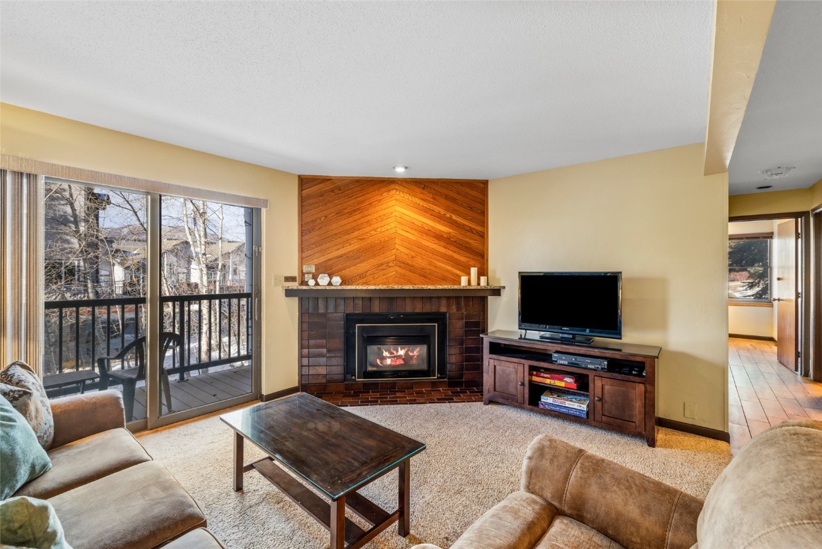 2015 Walton Creek Road, Unit 105 Steamboat Springs, CO 80487 - Photo 4 of 34 a living room with furniture a flat screen tv and a fireplace