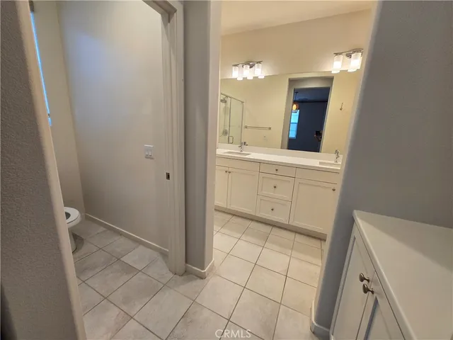 a spacious bathroom with a double vanity sink a mirror and a shower