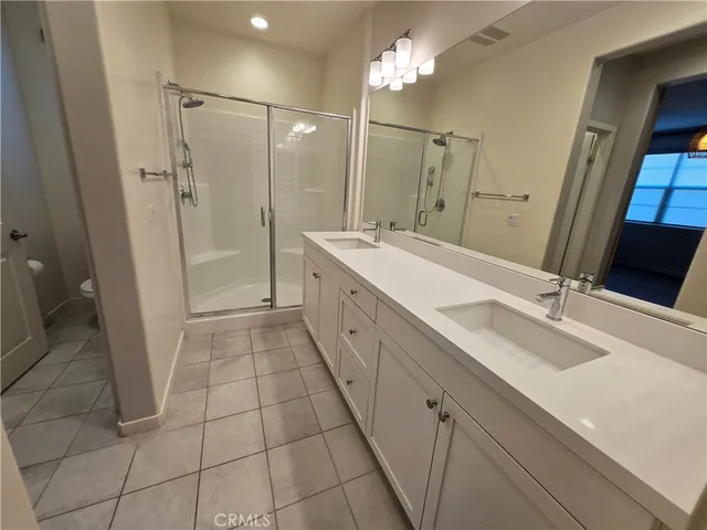a bathroom with a sink a toilet a mirror and shower