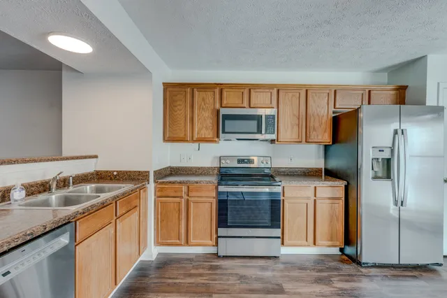 a kitchen with stainless steel appliances granite countertop a refrigerator stove and sink