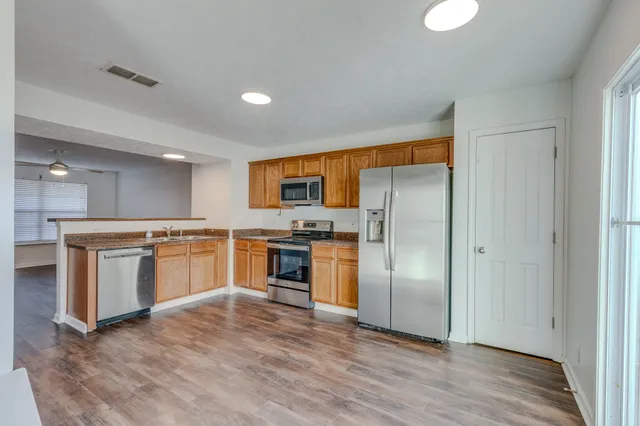 a kitchen with stainless steel appliances a refrigerator and a stove top oven