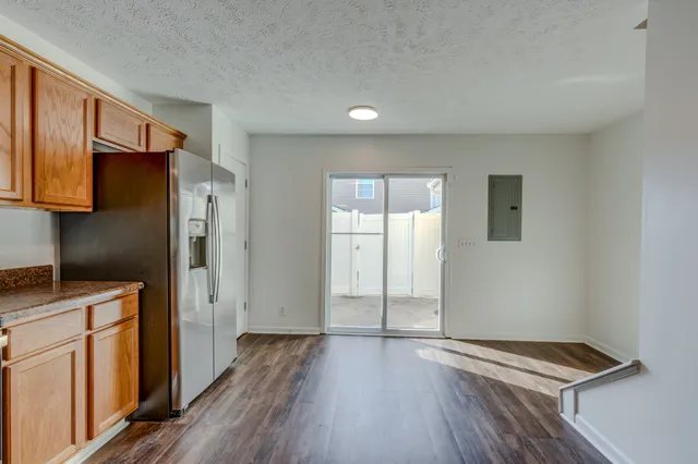 a view of kitchen with a refrigerator cabinets and wooden floor