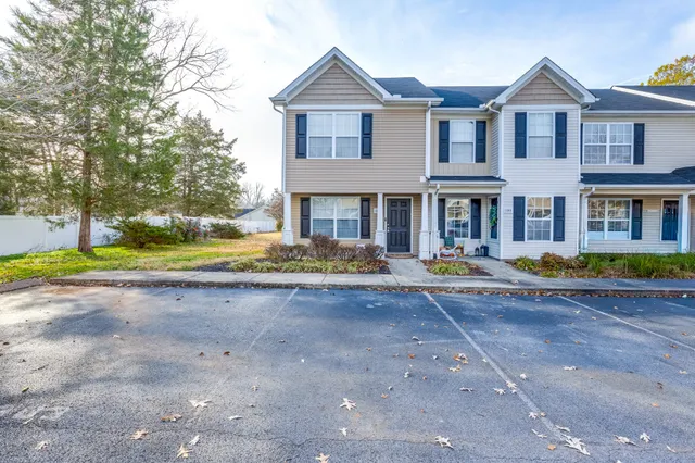 a front view of a house with a yard and sitting space