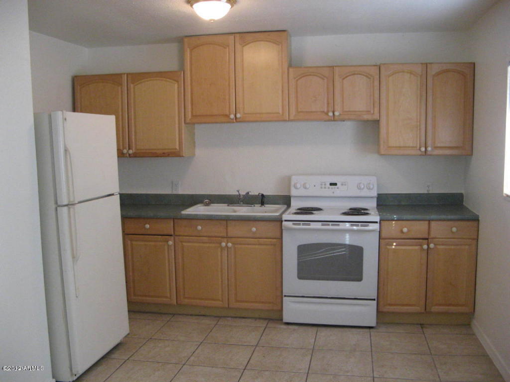 1537 West Pierce Street, Unit 2 Phoenix, AZ 85007 - Photo 2 of 3 a kitchen with a refrigerator sink and cabinets