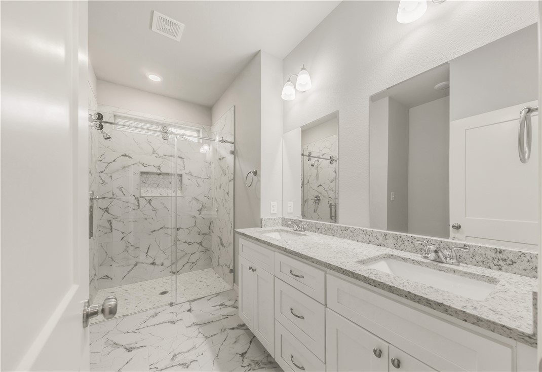 1803 Pin Oak Street Bryan, TX 77803 - Photo 10 of 17 a bathroom with a granite countertop sink mirror and shower