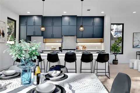 a kitchen with granite countertop kitchen island stainless steel appliances a dining table and chairs