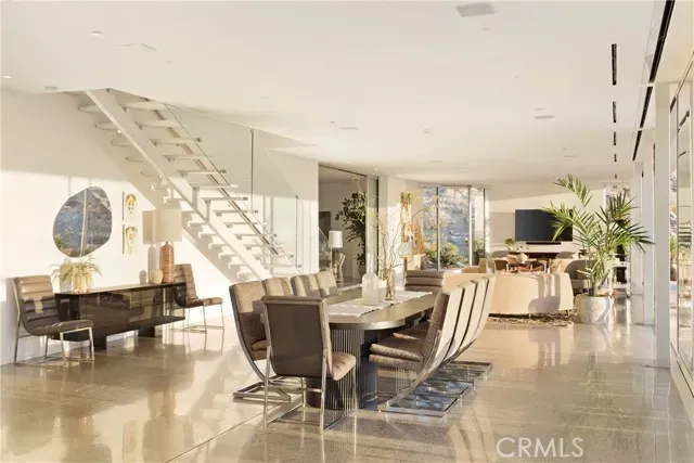 a room with a table chairs and windows